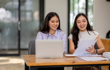 Financial Business two women analyze the graph of the company's performance to create profits and growth, Market research reports and income statistics, Financial and Accounting concept.	