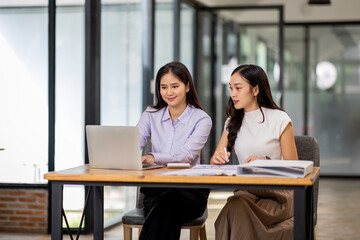 Financial Business two women analyze the graph of the company's performance to create profits and growth, Market research reports and income statistics, Financial and Accounting concept.	