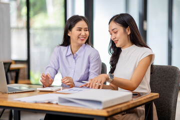 Financial Business two women analyze the graph of the company's performance to create profits and growth, Market research reports and income statistics, Financial and Accounting concept.	