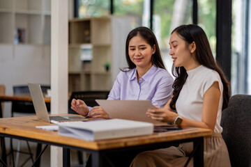 Financial Business two women analyze the graph of the company's performance to create profits and growth, Market research reports and income statistics, Financial and Accounting concept.	