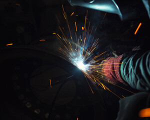worker welding with sparks in the factory