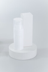Simple, minimalist mock up of a white cosmetic bottle and a rectangular box
