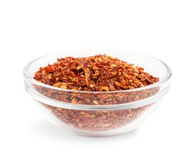 Side view of heap of dried spicy red hot chili pepper flakes with seeds in glass bowl isolated on white cultivated for pungency used as condiment for cooking as spice to add heat flavour for capsaicin