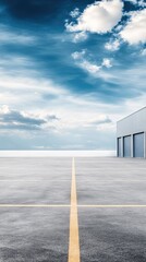 Obraz premium Industrial warehouse features gray exterior and garage doors, set against a bright blue sky, ideal for commercial storage purposes