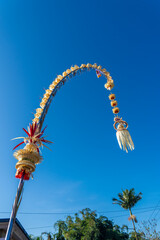 Beautiful penjors decorate the roadside during Galungan holiday in Bali Indonesia. Penjor is a Balinese Hindu religious symbol of prosperity installed on the day of the Galungan ceremony.