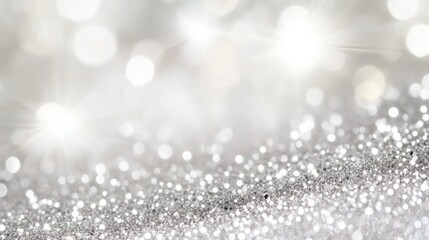 Fototapeta premium Sparkling silver glitter background with bright white bokeh lights suggesting celebration, luxury events, or holiday advertising themes.