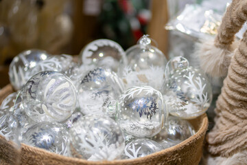 Many transparent glass Christmas balls in a beige textile basket