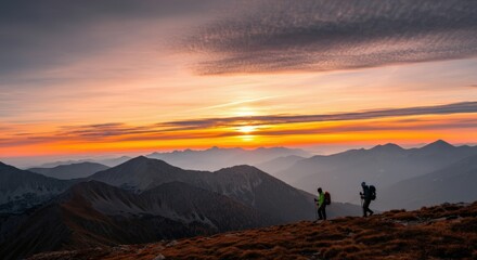Fototapeta premium Hikers at Sunset Over Mountain Range