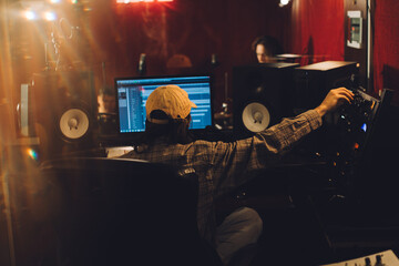 Audio engineer fine-tuning settings on a mixing console