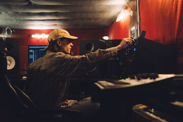 Audio engineer fine-tuning settings on a mixing console