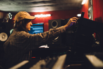 Sound technician working on audio equipment in a recording studio