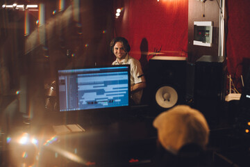 Drummer and sound engineer collaborating in a professional recording studio