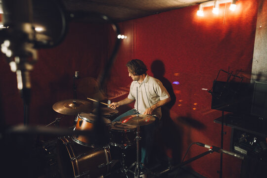 Drummer experimenting with new sounds in a music studio - Powered by Adobe