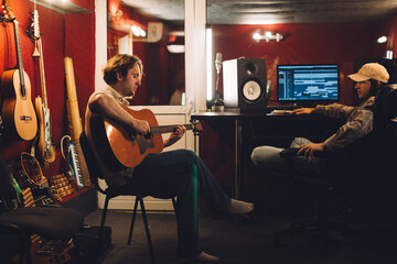 Musician preparing a song while producer listens