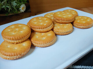 Sandwich crackers filled with peanut butter flavored cream in white plate
