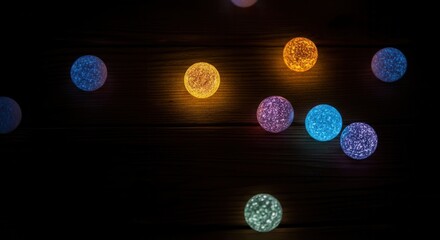 Colorful glowing orbs on wooden background