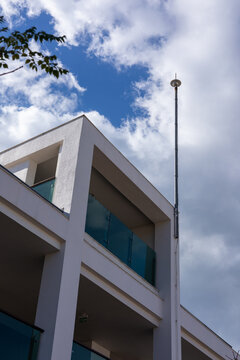 Modern hotel architecture in Turkiye with a tall antenna against a cloudy sky