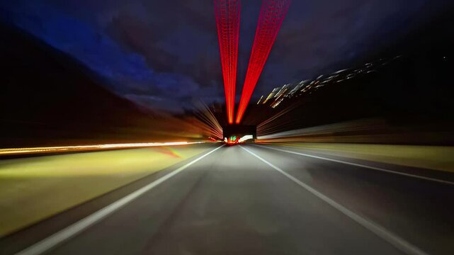 Timelapse of road drive along the highway. Front view to the road and surrounding landscapes. Trees stretch on both sides of road. Fast car hyperlapse. Road trip travel concept sort of dashcam POV