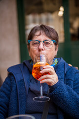 A woman drinks a cocktail in a café in Verona,Italy