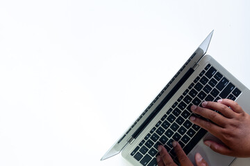 Fototapeta premium Selective Focus Top View of a Hand Typing on a Laptop Over a White Background, Minimalist Technology Concept.