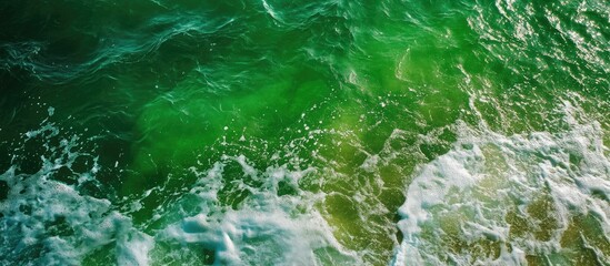 Emerald green ocean waves gently lapping the shore creating a tranquil beach scene perfect for relaxation and nature lovers.