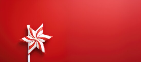 Festive red background with a white straw star and striped candy cane ideal for postcard design or holiday greeting text placement.