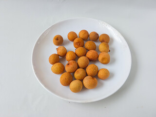longan fruit on a white round plate isolate on white background