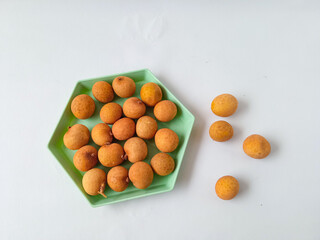 longan fruit on a green hexagon plate isolate on white background