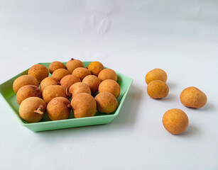 longan fruit on a green hexagon plate isolate on white background