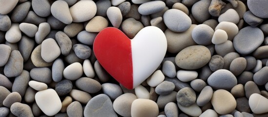Red heart shaped stone resting on smooth white pebbles symbolizes love and tranquility in a serene natural setting.