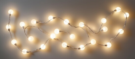 Festive electric garland with round white LED lamps glowing brightly for cheerful holiday decorations