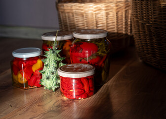 beautiful wicker baskets on the floor, homemade products in jars, canned tomatoes and peppers, chilli, autumn harvest