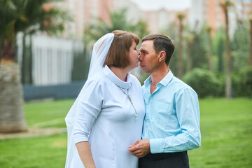 Fototapeta premium An adult bride and groom. Husband and wife's wedding anniversary photo shoot. We've been together for 30 years.