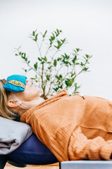 Woman in a cosy yin, restorative yoga pose setup on a terrace