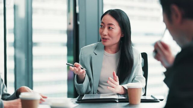 Japanese woman, group meeting and discussion for business solution, brainstorming and progress update. Collaboration, planning project and leader with team, program manager and feedback in office