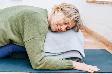 Close-up of a serene woman enjoying restorative yoga on an outdoor terrace