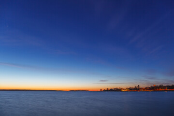 Full moon rising over the Baltic sea, sea shore view, late sunset time