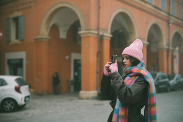 Fototapeta premium A woman is carefully taking a picture of a building using a camera