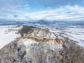 Luftbild vom verschneiten Hegauvulkan Mägdeberg mit Mauerresten einer Burg an einem kalten Wintermorgen