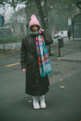 A woman elegantly wears a bright pink hat and matching scarf