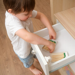 A baby holding a matchstick poses a serious fire safety concern. Playing with fire indoors is a...