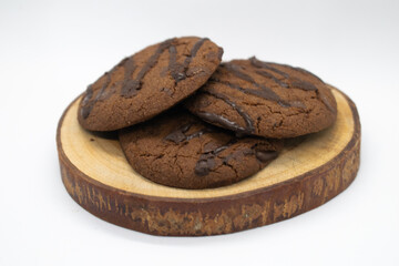 Chocolate chip cookies on wood slice with white background