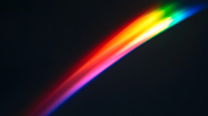 Fototapeta premium Vibrant rainbow arc created by light dispersion in a dark environment during early evening