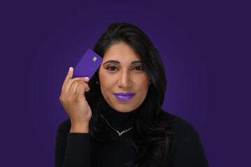 woman with credit card near head smiling confidently, on purple background