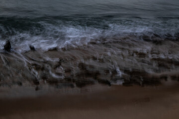 Intentional camera movement. Sea edge at blue hour. Calm and peaceful sea before dusk.