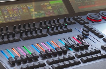 Professional audio mixing console with colorful faders.