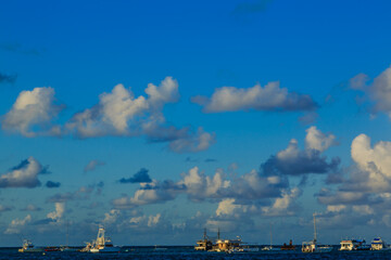 Obraz premium A blue sky with a few clouds and a few boats in the water