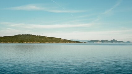 Serene sea with distant islands under blue sky