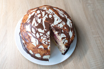 Chocolate pie Milchmadchen with cheese cream sauce with banana and cherry on the wooden background....