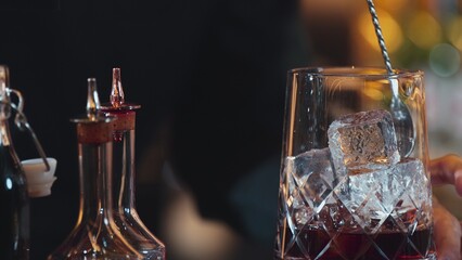 Closeup hand bartender holding jigger to measure liquor sugar into mixing glass ingredients alcohol preparation creative mixed cocktail. Special refresh drink showcasing nightlife mixology. Vinosity.